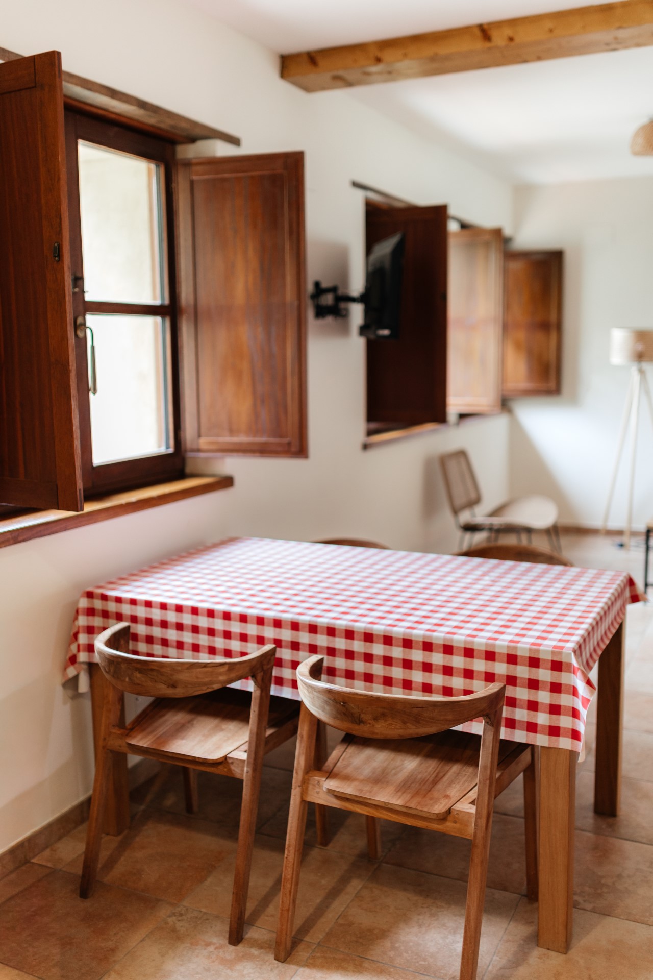Mesa-de-comedor-con-mantel-de-cuadros-rojos-en-cocina-de-casa-rural-en-Llanes
